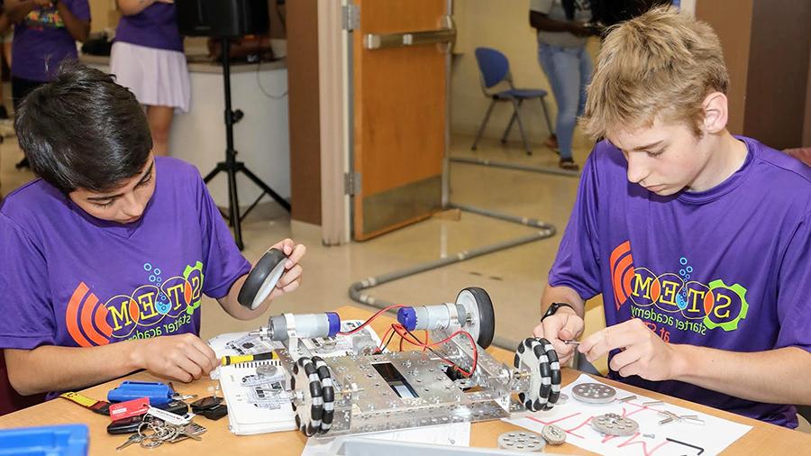 young participants assembling a robot together